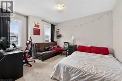 Bedroom with an office area, light carpet, and a textured ceiling - 