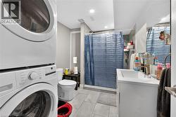 Bathroom with vanity, a stall shower, recessed lighting, stacked washer / dryer, and light tile patterned floors - 