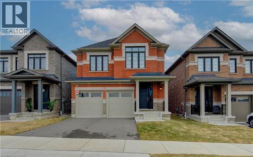 Craftsman-style house featuring driveway, an attached garage, a front yard, and brick siding - 39 Guernsey Drive, Kitchener, ON - Outdoor With Facade