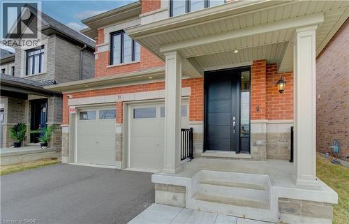 View of exterior entry featuring a porch, asphalt driveway, brick siding, and a garage - 39 Guernsey Drive, Kitchener, ON - Outdoor