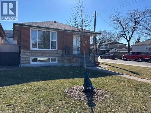 View of front of home featuring a front yard, stone siding, brick siding, and roof with shingles - 1224 Dunsmure Road, Hamilton, ON - Outdoor