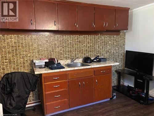 Kitchen with light countertops, ornamental molding, dark wood-style flooring, and backsplash - 1224 Dunsmure Road, Hamilton, ON - Indoor