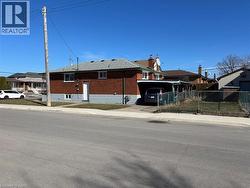 View of front of property with brick siding, driveway, and a carport - 