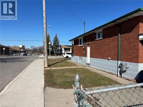 View of side of property with a yard and brick siding - 1224 Dunsmure Road, Hamilton, ON - Outdoor With Exterior