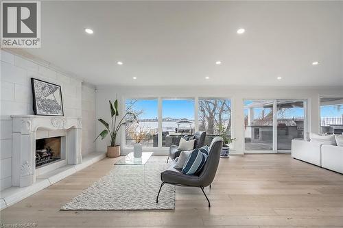 Living room featuring a large fireplace, light wood-type flooring, and recessed lighting - 624 North Shore Boulevard E, Burlington, ON - Indoor Photo Showing Living Room With Fireplace