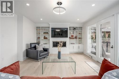 Living area with light wood-style flooring, a glass covered fireplace, and recessed lighting - 624 North Shore Boulevard E, Burlington, ON - Indoor Photo Showing Living Room With Fireplace