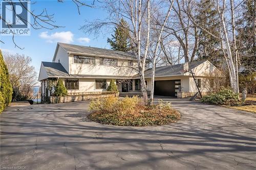 View of front facade with driveway, a garage, and stucco siding - 624 North Shore Boulevard E, Burlington, ON - Outdoor