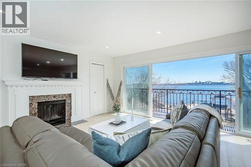 Living area featuring a premium fireplace, a water view, and recessed lighting - 624 North Shore Boulevard E, Burlington, ON - Indoor Photo Showing Living Room With Fireplace