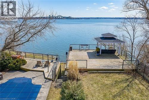 Dock featuring a deck with water view, a covered pool, and a yard - 624 North Shore Boulevard E, Burlington, ON - Outdoor With Body Of Water With Deck Patio Veranda With View