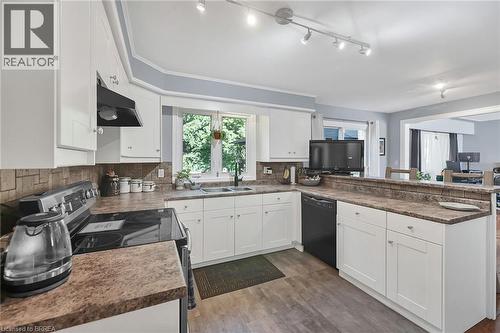 Kitchen with white cabinetry, a peninsula, electric stove, dishwasher, and dark countertops - 56 Forsythe Avenue, Brantford, ON - Indoor Photo Showing Kitchen With Double Sink
