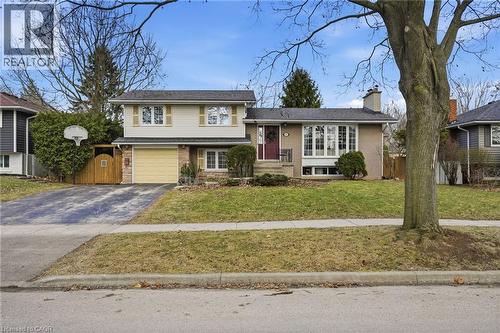 Split level home featuring brick siding, driveway, a chimney, and a garage - 227 Walden Drive, Burlington, ON - Outdoor With Facade