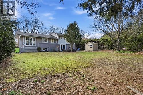 Back of house featuring brick siding, a chimney, a shed, and a lawn - 227 Walden Drive, Burlington, ON - Outdoor