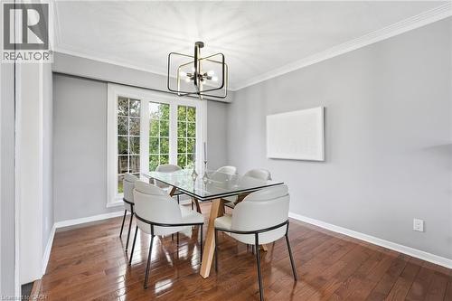 Dining area featuring ornamental molding, dark wood-type flooring, and a chandelier - 227 Walden Drive, Burlington, ON - Indoor Photo Showing Dining Room