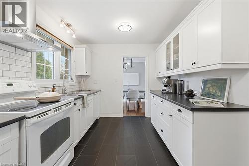 Kitchen with white electric range, range hood, dark countertops, and white cabinetry - 227 Walden Drive, Burlington, ON - Indoor Photo Showing Kitchen