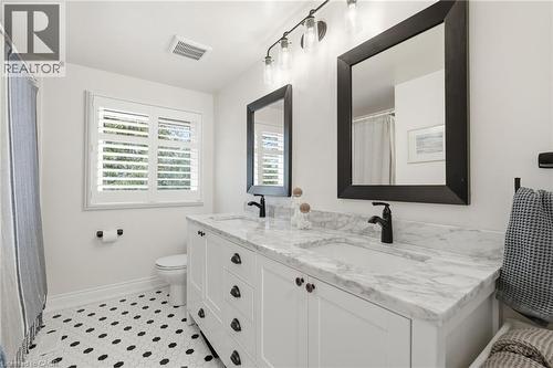 Bathroom featuring double vanity, a shower with shower curtain, and light tile patterned flooring - 227 Walden Drive, Burlington, ON - Indoor Photo Showing Bathroom