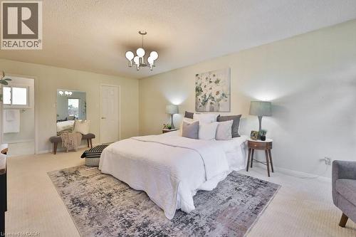 Bedroom with light colored carpet, a textured ceiling, and hanging lights - 700 Fieldstone Road, Mississauga, ON - Indoor Photo Showing Bedroom