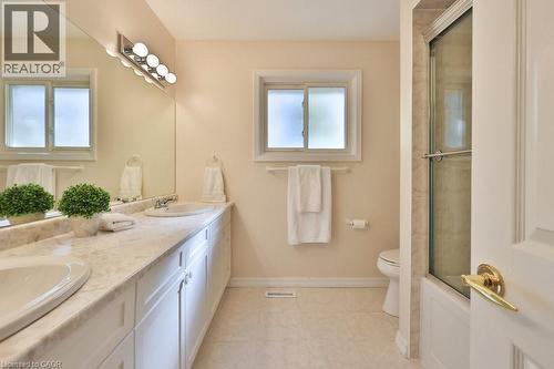 Full bathroom with double vanity, combined bath / shower with glass door, and light tile patterned floors - 700 Fieldstone Road, Mississauga, ON - Indoor Photo Showing Bathroom