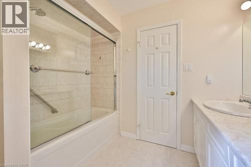 Bathroom featuring vanity, shower / bath combination with glass door, and light tile patterned flooring - 700 Fieldstone Road, Mississauga, ON - Indoor Photo Showing Bathroom