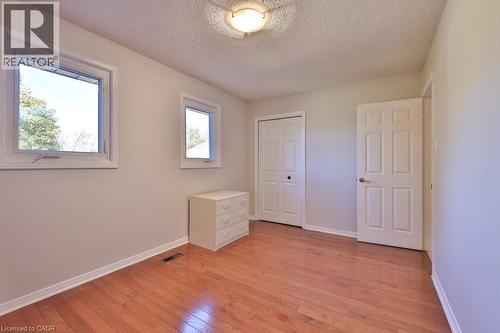 Unfurnished bedroom featuring light wood-type flooring, a textured ceiling, and a closet - 700 Fieldstone Road, Mississauga, ON - Indoor Photo Showing Other Room