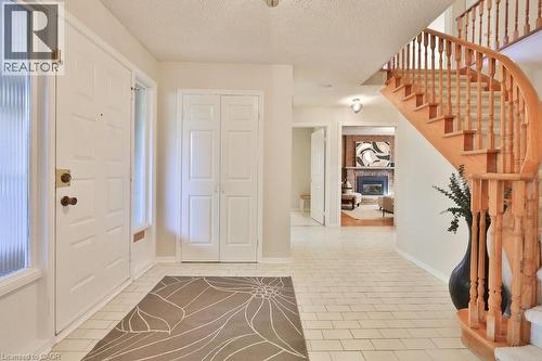 Foyer entrance featuring a textured ceiling and a brick fireplace - 700 Fieldstone Road, Mississauga, ON - Indoor Photo Showing Other Room