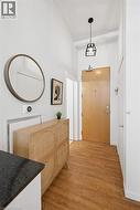 Hallway featuring light wood finished floors and a high ceiling - 