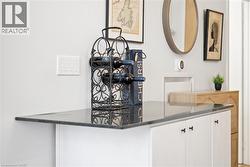 Detailed view of white cabinetry and dark stone countertops - 