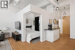 Bedroom featuring a high ceiling and light wood-type flooring - 