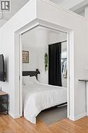 Bedroom with light wood-style floors, a closet, and crown molding - 