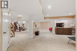 Finished below grade area with light colored carpet and recessed lighting - 