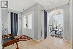 Entryway with plenty of natural light, light tile patterned floors, hanging lights, and french doors - 