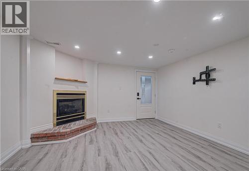 Unfurnished living room with light wood-style floors, a glass covered fireplace, and recessed lighting - 383 Rexford Drive Unit# 2, Hamilton, ON - Indoor With Fireplace
