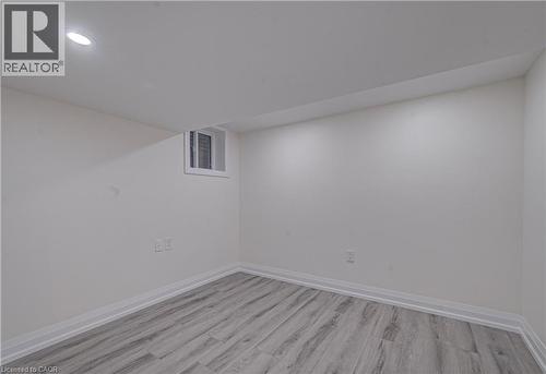 Finished below grade area with light wood-style flooring and baseboards - 383 Rexford Drive Unit# 2, Hamilton, ON - Indoor Photo Showing Other Room