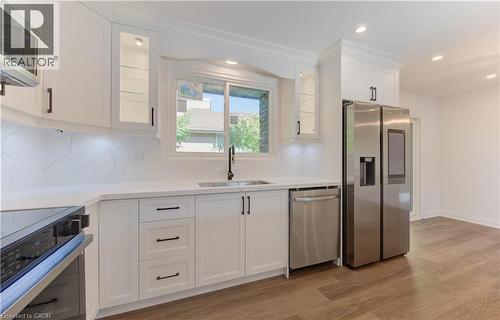 Kitchen featuring stainless steel appliances, glass insert cabinets, white cabinetry, light wood-style flooring, and recessed lighting - 90 Culpepper Drive, Waterloo, ON - Indoor Photo Showing Kitchen With Upgraded Kitchen