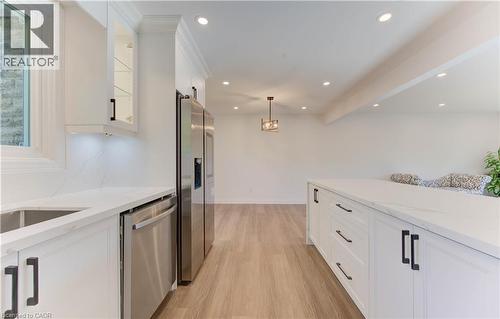Kitchen featuring white cabinets, light stone countertops, decorative light fixtures, appliances with stainless steel finishes, and recessed lighting - 90 Culpepper Drive, Waterloo, ON - Indoor Photo Showing Kitchen With Upgraded Kitchen