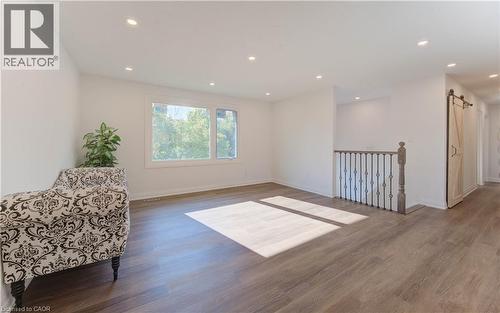 Living area with a barn door, wood finished floors, recessed lighting, and an upstairs landing - 90 Culpepper Drive, Waterloo, ON - Indoor Photo Showing Other Room