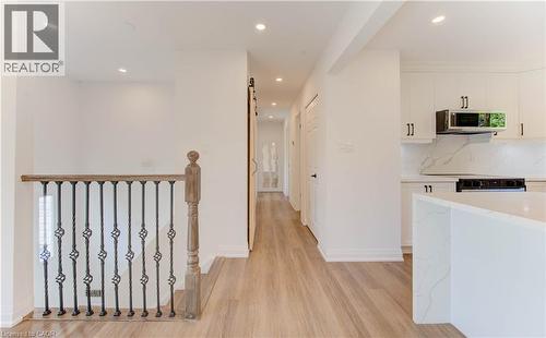 Hall featuring a barn door, recessed lighting, and light wood-style floors - 90 Culpepper Drive, Waterloo, ON - Indoor