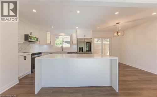 Kitchen featuring recessed lighting, white cabinetry, hanging light fixtures, appliances with stainless steel finishes, and a center island - 90 Culpepper Drive, Waterloo, ON - Indoor Photo Showing Kitchen With Upgraded Kitchen