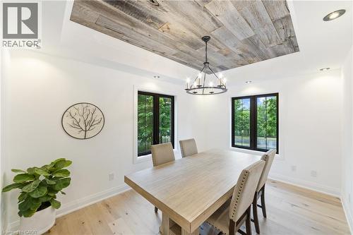 Dining space featuring large windows, tray ceiling with barn board finish, additional recessed lighting, chandelier - 515 Hamilton Drive, Ancaster, ON - Indoor Photo Showing Dining Room