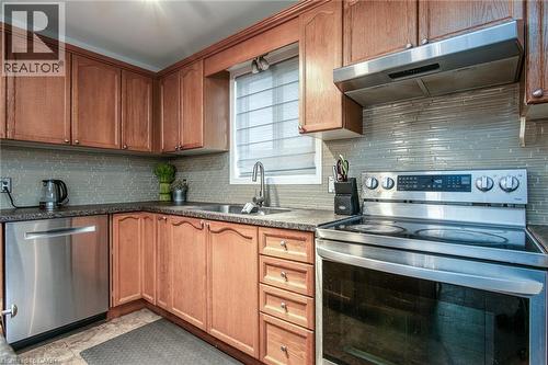 Kitchen featuring stainless steel appliances, tasteful backsplash, and wood finish cabinetry - 236 Dartmoor Crescent, Waterloo, ON - Indoor Photo Showing Kitchen