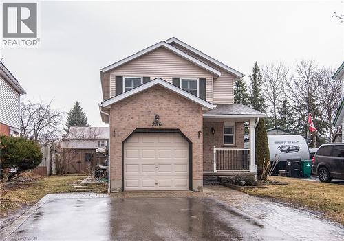 Traditional-style home with a porch, asphalt driveway, a gate, a garage, and brick siding - 236 Dartmoor Crescent, Waterloo, ON - Outdoor