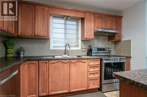 Kitchen featuring dark countertops, electric stove, wood finish cabinets, and decorative backsplash - 236 Dartmoor Crescent, Waterloo, ON - Indoor Photo Showing Kitchen