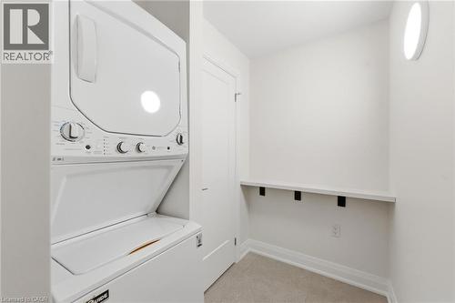 Laundry room with baseboards and stacked washing machine and dryer - 187 Oak Avenue Unit# Lower, Hamilton, ON - Indoor Photo Showing Laundry Room