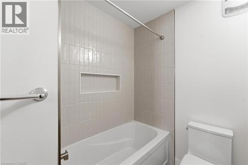 Bathroom featuring toilet and bathing tub / shower combination - 187 Oak Avenue Unit# Lower, Hamilton, ON - Indoor Photo Showing Bathroom