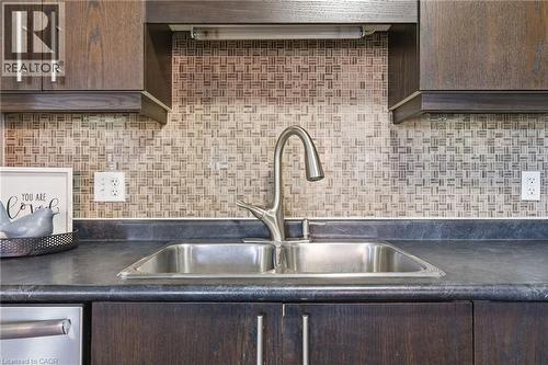 Kitchen with dark wood finish cabinets, dark countertops, backsplash, and stainless steel dishwasher - 208 Templewood Drive, Kitchener, ON - Indoor Photo Showing Kitchen With Double Sink