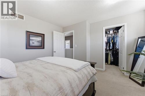 Bedroom with light colored carpet, a walk in closet, and a textured ceiling - 208 Templewood Drive, Kitchener, ON - Indoor Photo Showing Bedroom