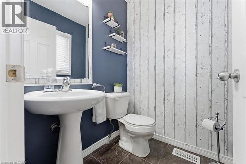 Half bathroom with toilet and dark tile patterned floors - 208 Templewood Drive, Kitchener, ON - Indoor Photo Showing Bathroom