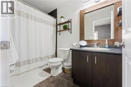 Full bath featuring vanity, shower / bath combination with curtain, and dark tile patterned floors - 208 Templewood Drive, Kitchener, ON - Indoor Photo Showing Bathroom
