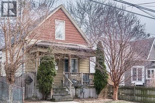 Beautiful streetscape with mature trees and an expansive front porch, creating a welcoming space to relax and engage with your neighbors. - 500 Ferguson Avenue N, Hamilton, ON - Outdoor