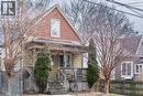 Beautiful streetscape with mature trees and an expansive front porch, creating a welcoming space to relax and engage with your neighbors. - 500 Ferguson Avenue N, Hamilton, ON  - Outdoor 