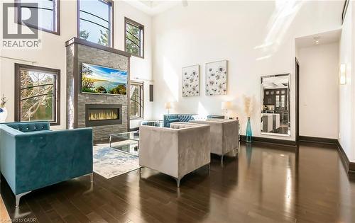 Living area with a stone fireplace, wood finished floors, and a high ceiling - 24 Jacob Gingrich Drive, Kitchener, ON - Indoor With Fireplace